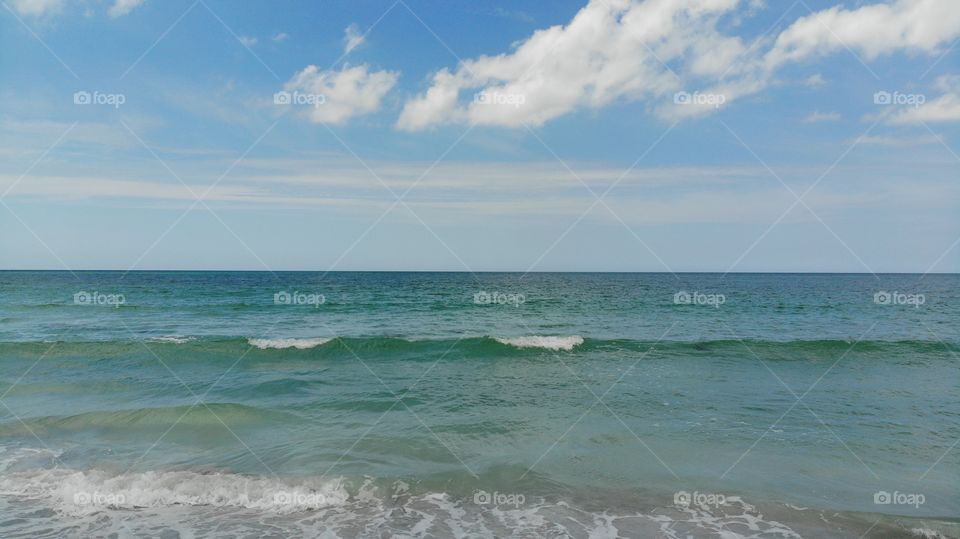 Above view gulf of Mexico. Tropical blue sea and blue sky with sun, clouds. clear water in the ocean. A blue, green, sea surface for background. View From above, flat lay. water horizon bird's eye.