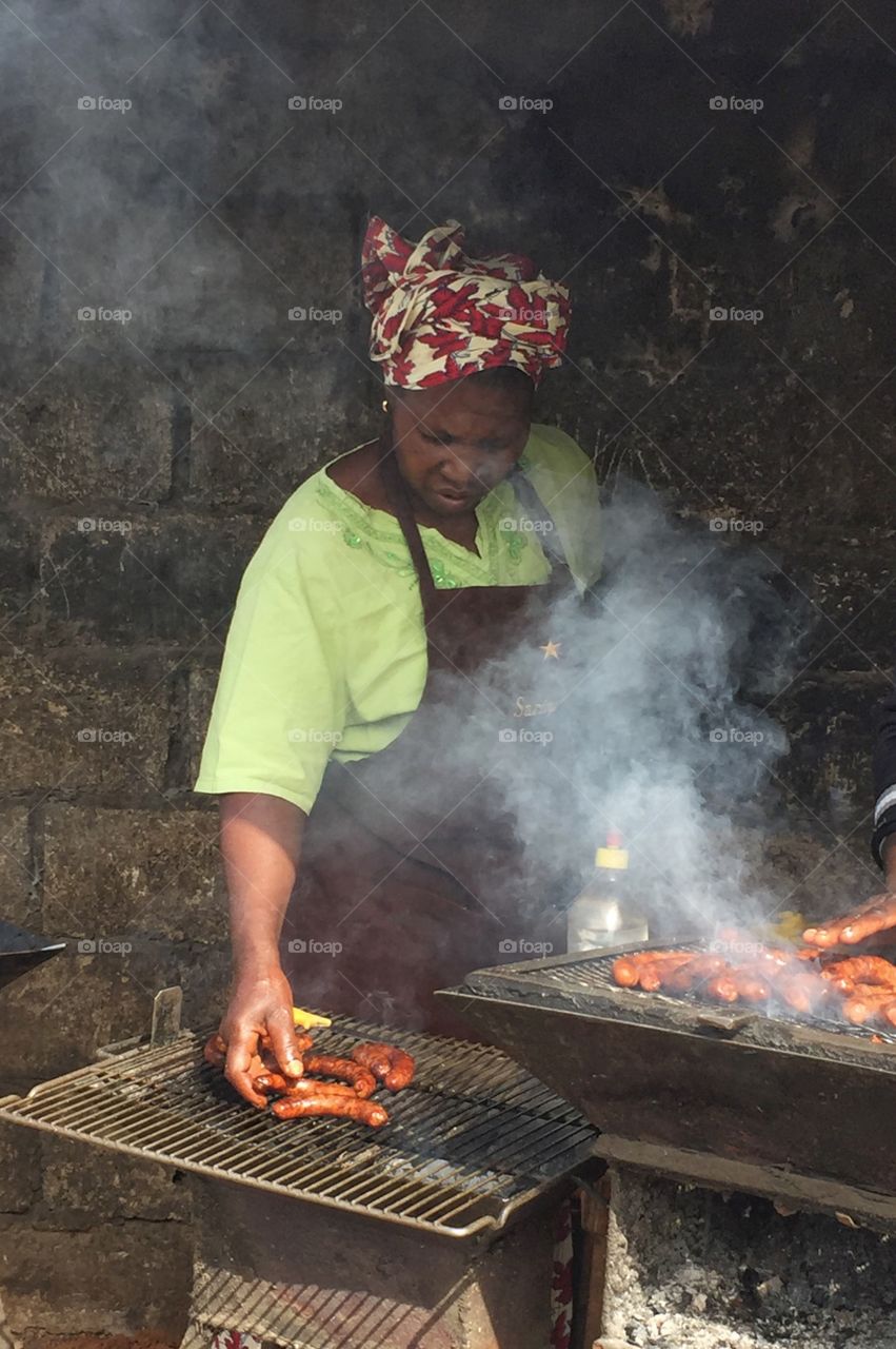 African woman preparing sausage
