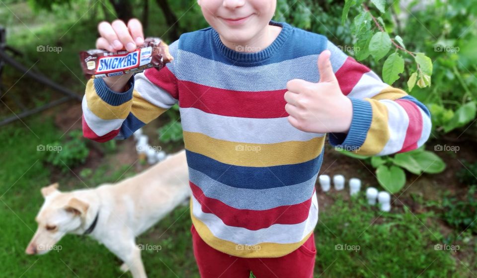 smiling boy holds a snickers