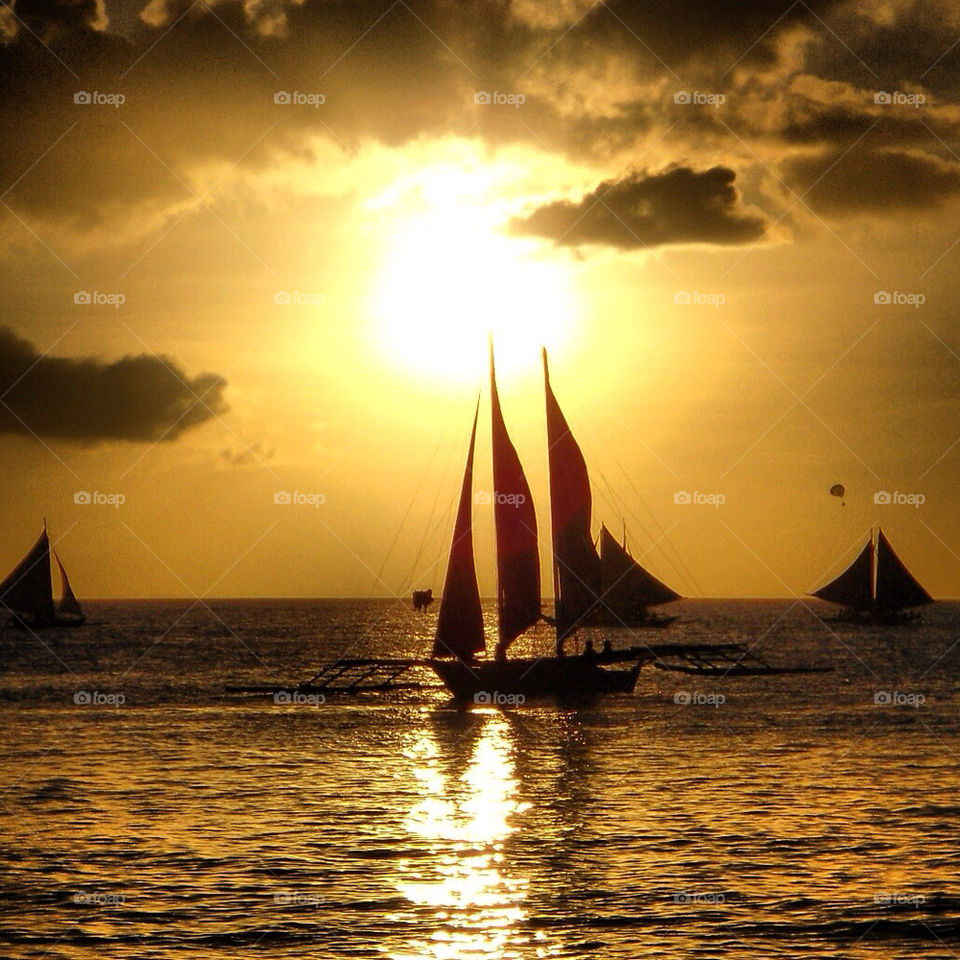 Sunset on Boracay island. Silhouette boat sailing in the ocean