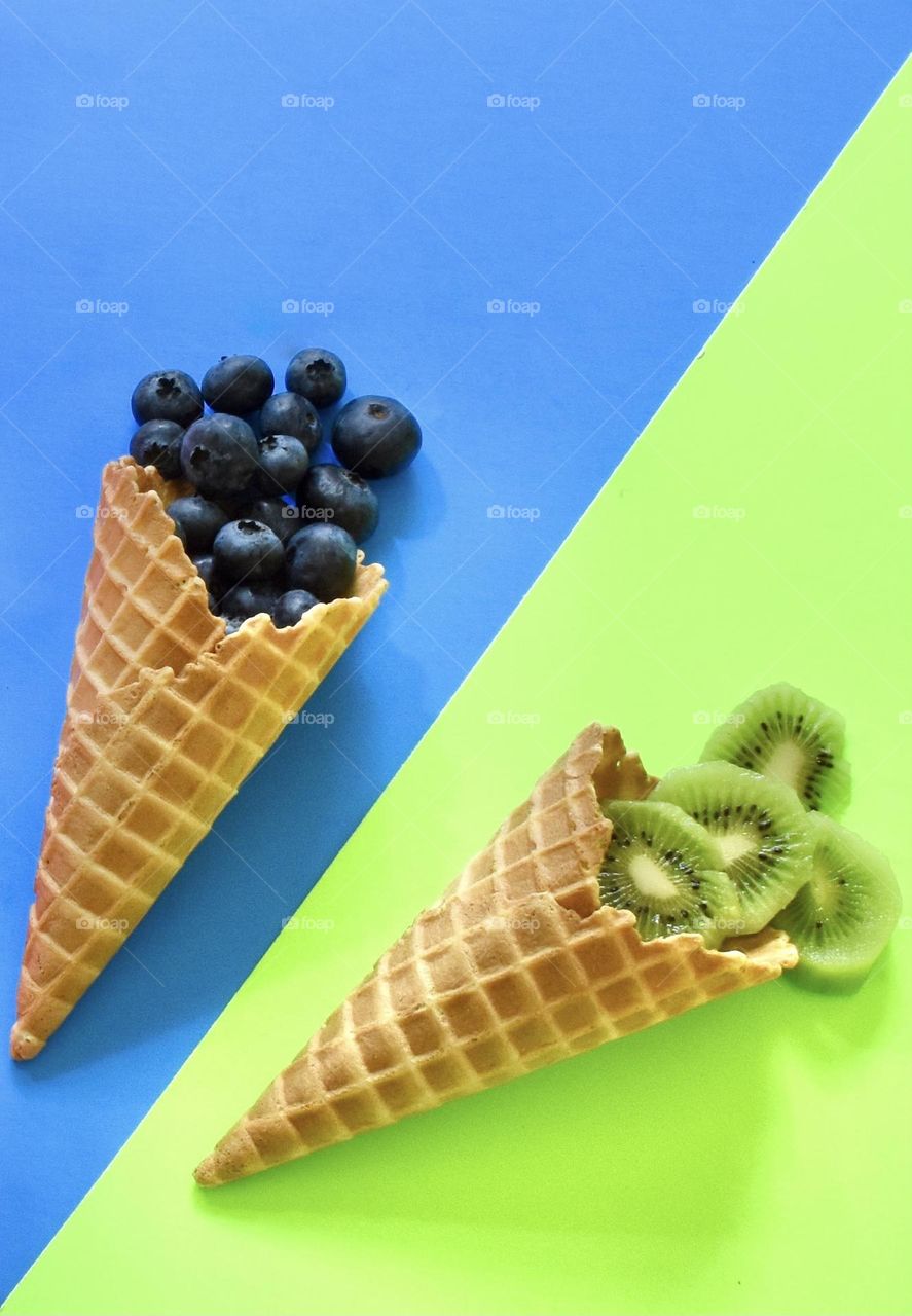 Blueberries and kiwis in waffle cones