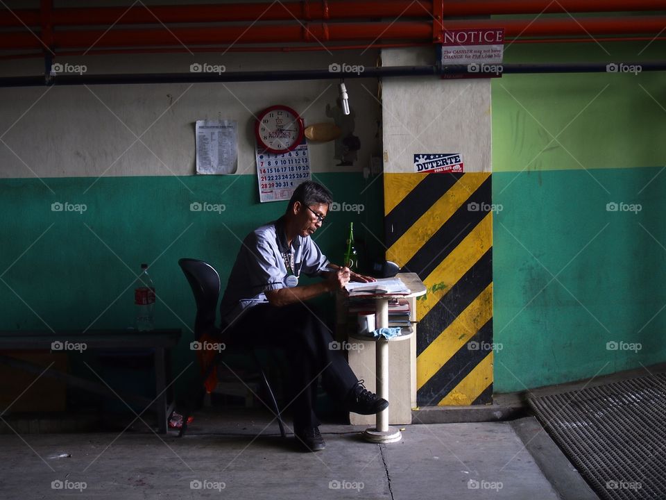 man writing on a desk in a basement