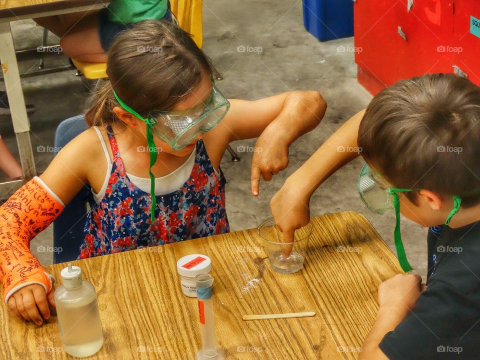 Desk From Above. Students Performing A Science Experiment
