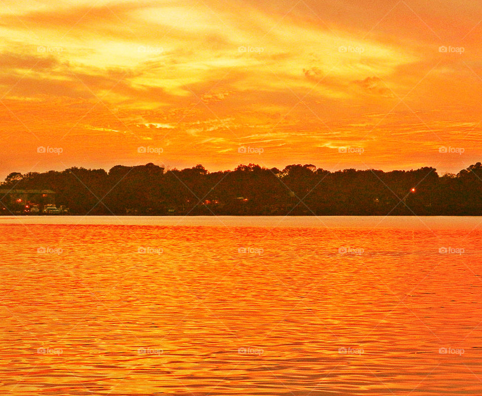 Fluorescent Majesty. This fluorescent sunset radiates it's orange and tangerine colored reflection on the calm waters of the Choctawhatchee!