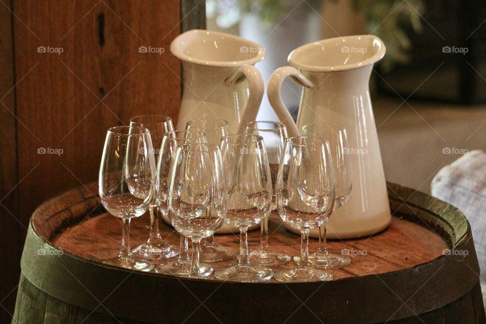 Crystal clear group of empty wine glasses on wood tray with two pure white ceramic water jugs, still life; concept cleansing the palate for wine tasting, winery, celebration, party, refreshments, wedding, serving, wine tours and sampling