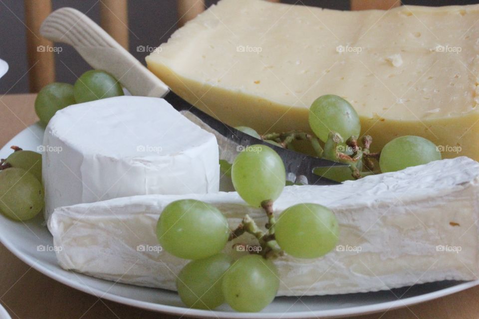 Variety of cheese and grapes in plate
