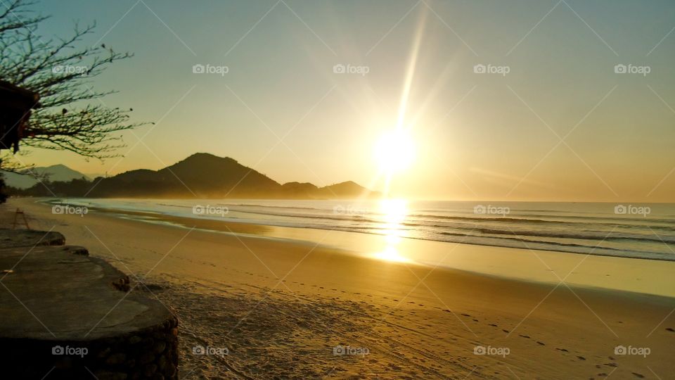 O pôr do sol na praia.