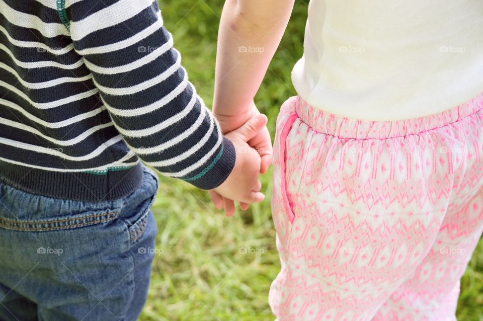 Midsection view of friends holding hands