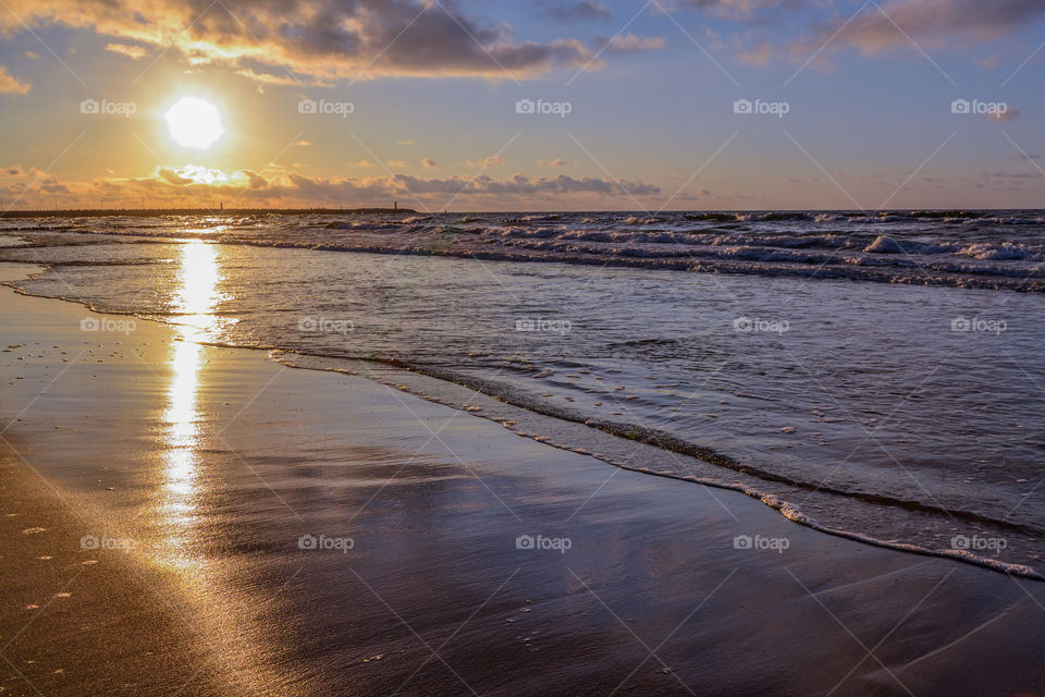 View of waves on beach at sunset
