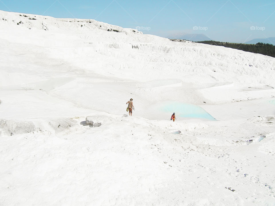 Tiny human walking by the white chalk mountain Pamukkale in Turkey 🇹🇷