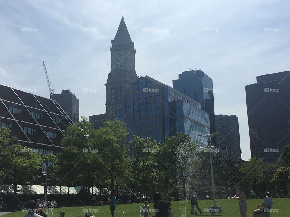 Towering building behind summer fountain and courtyard 