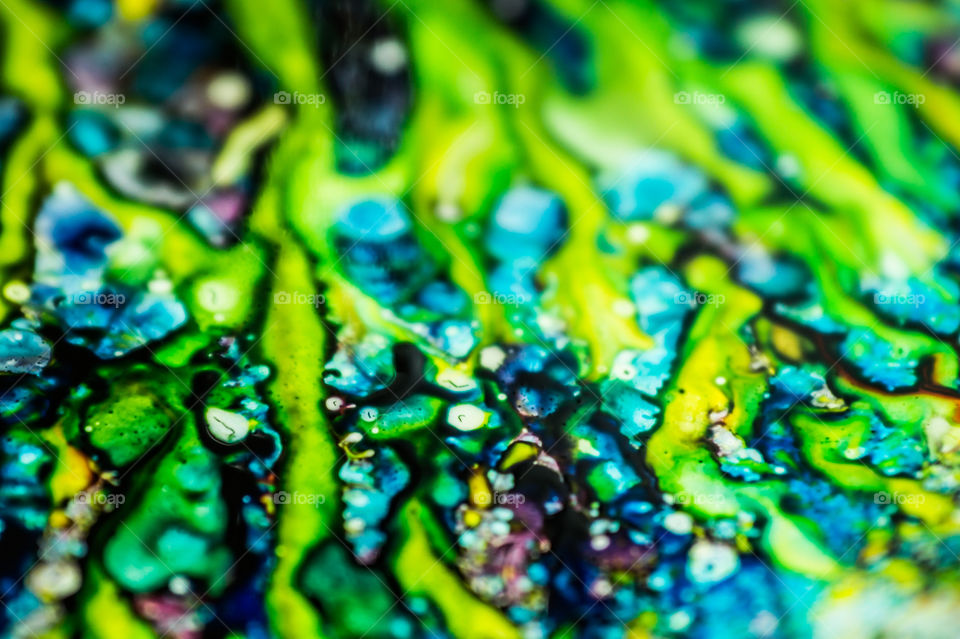 The ink to refill the printer cartridge was spilled onto the white washbasin and the paints blended into abstract drips and patterns