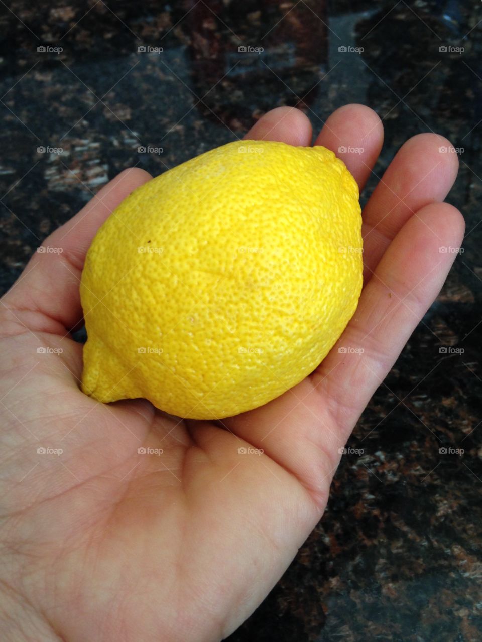 Close-up of a lemon on hand