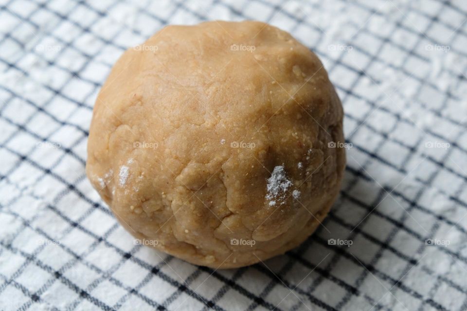 Close up of ready dough for American peanut butter cookies  on the checkered napkin and flour