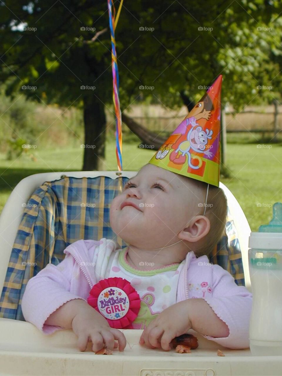 Birthday girl looking up at her balloon. 