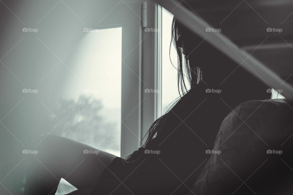 Beautiful girl is sitting near a window