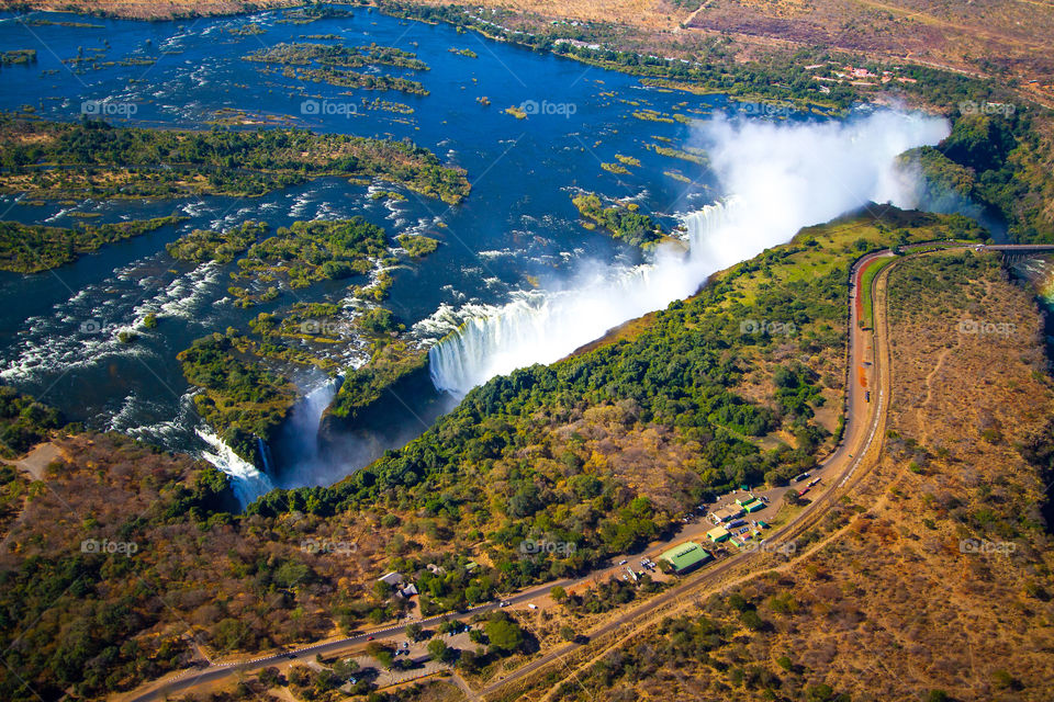 Aerial image of the Victoria Falls, one of the seven natural wonders of the world. The Vic falls forms the border between Zimbabwe and Zambia, Africa. The waterfall is the largest stretching 1708km (5604ft) and is 108m (354ft) high.