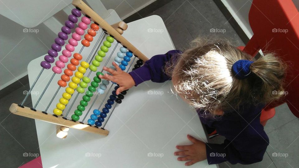 A child plays by Colored pellet setup.