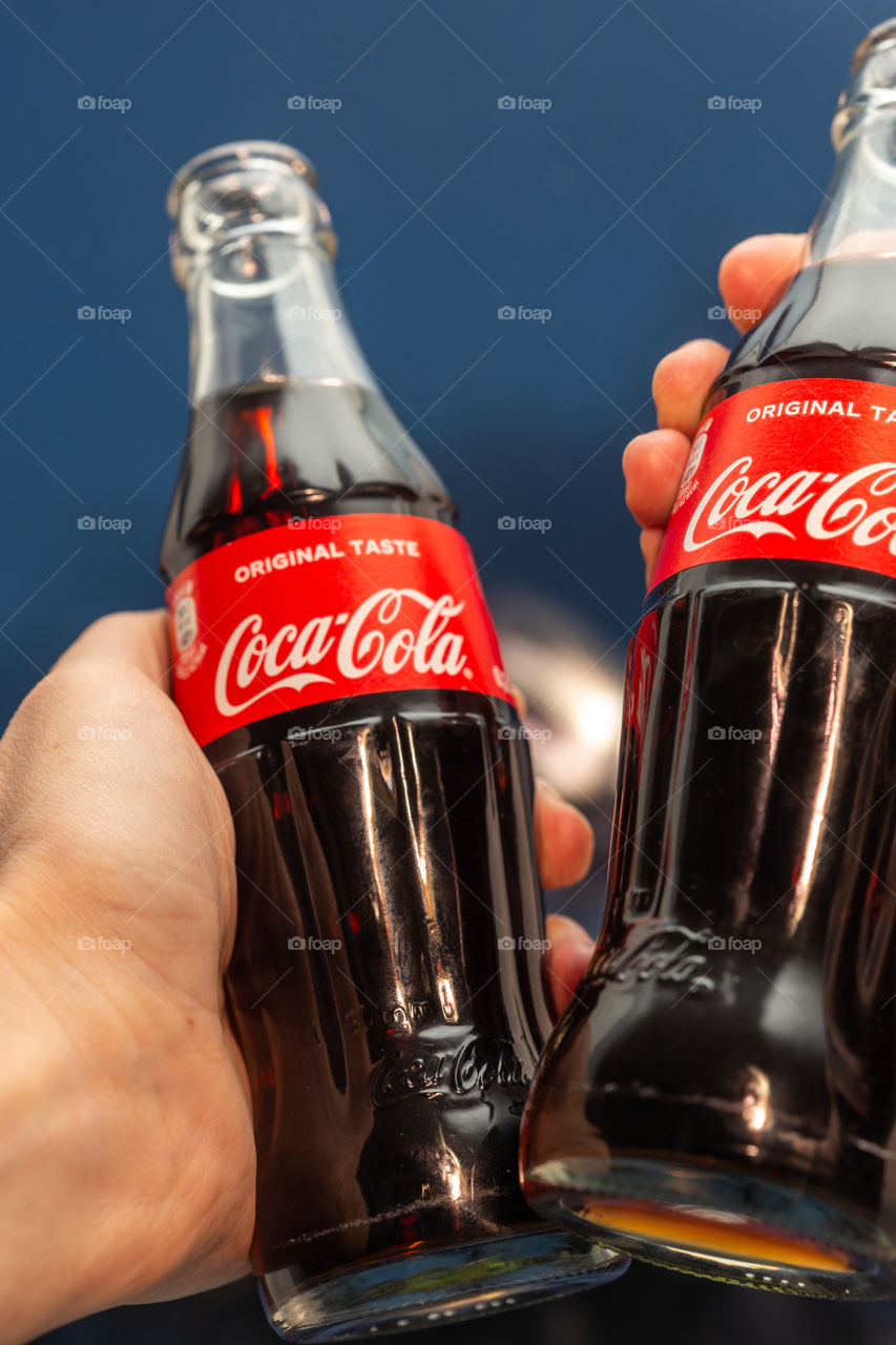two bottles of Coca Cola and hands