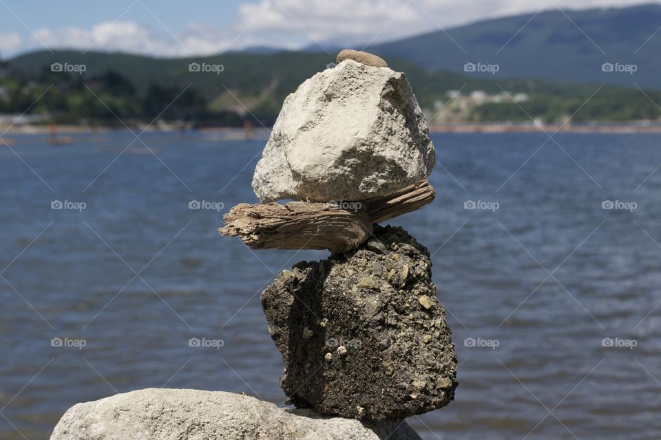 Grey stone stack like against blurred ocean horizon 