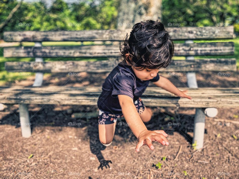 Child falling from bench in public park, toddler falling down, toddler fears falling, mother fears her child will get hurt, mother watches as toddler falls, mother fears child will get hurt, falling in motion, action picture of fall