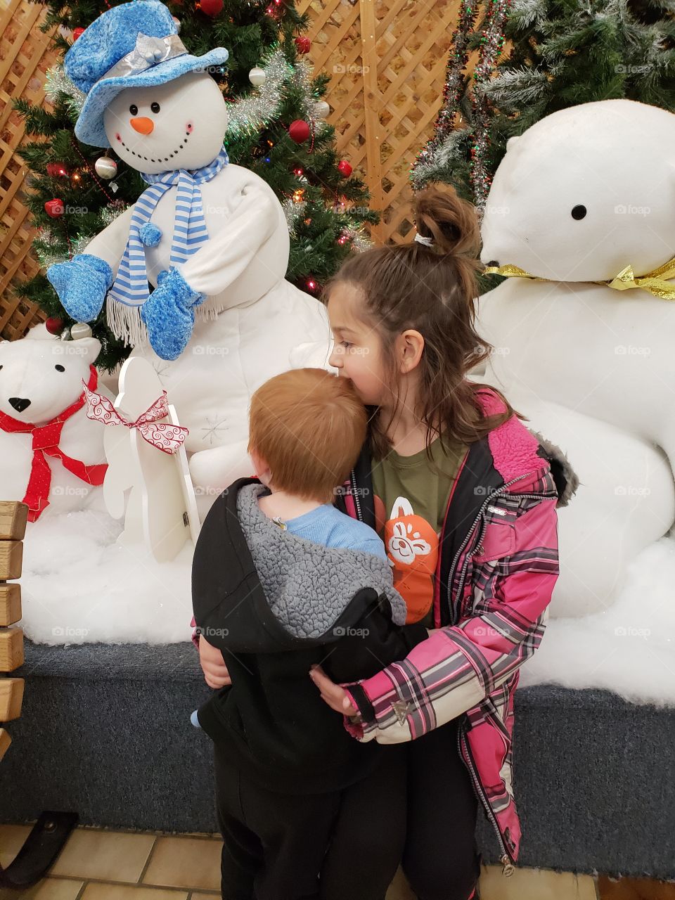 child hugging toddler