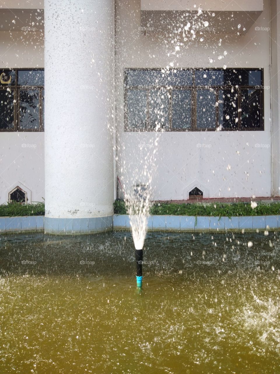 The fountains in the pond in front of the building for decoration.