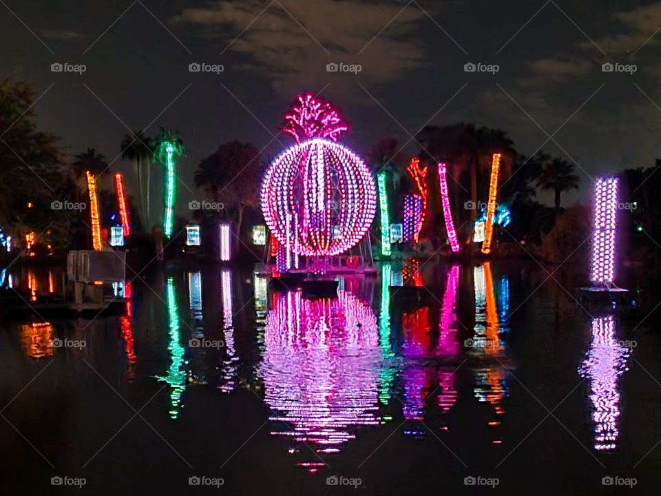 The lights of a beautiful Christmas event are reflected on a calm lake