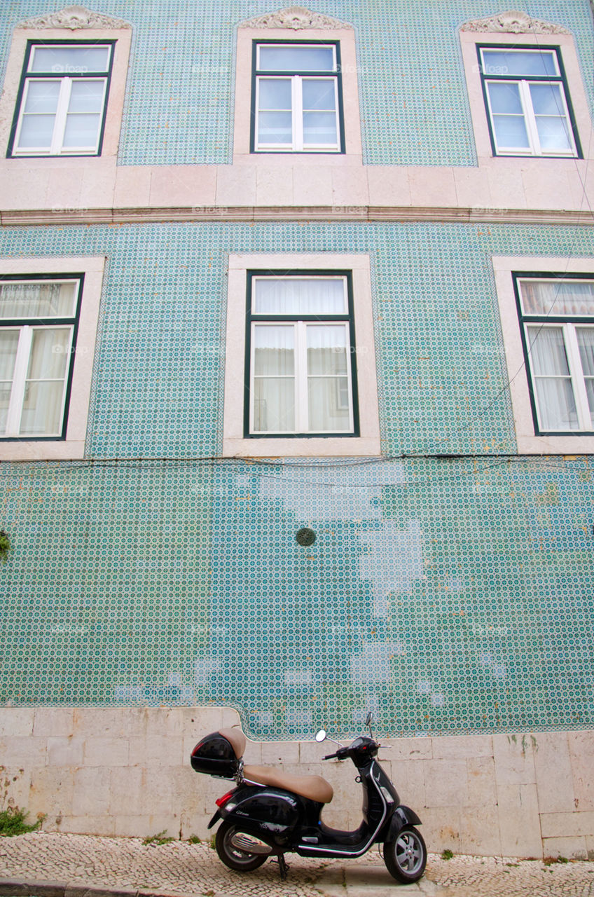 Scooter parked in front of a tiled building in Lisbon, Portugal 