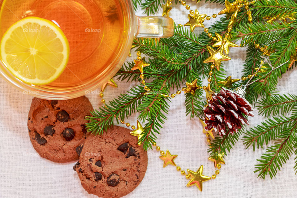 Close-up of lemon tea with cookies near christmas ornaments