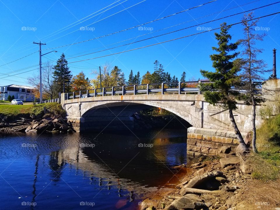 Bridge over the river in the small town with clear blue sky and bright water.