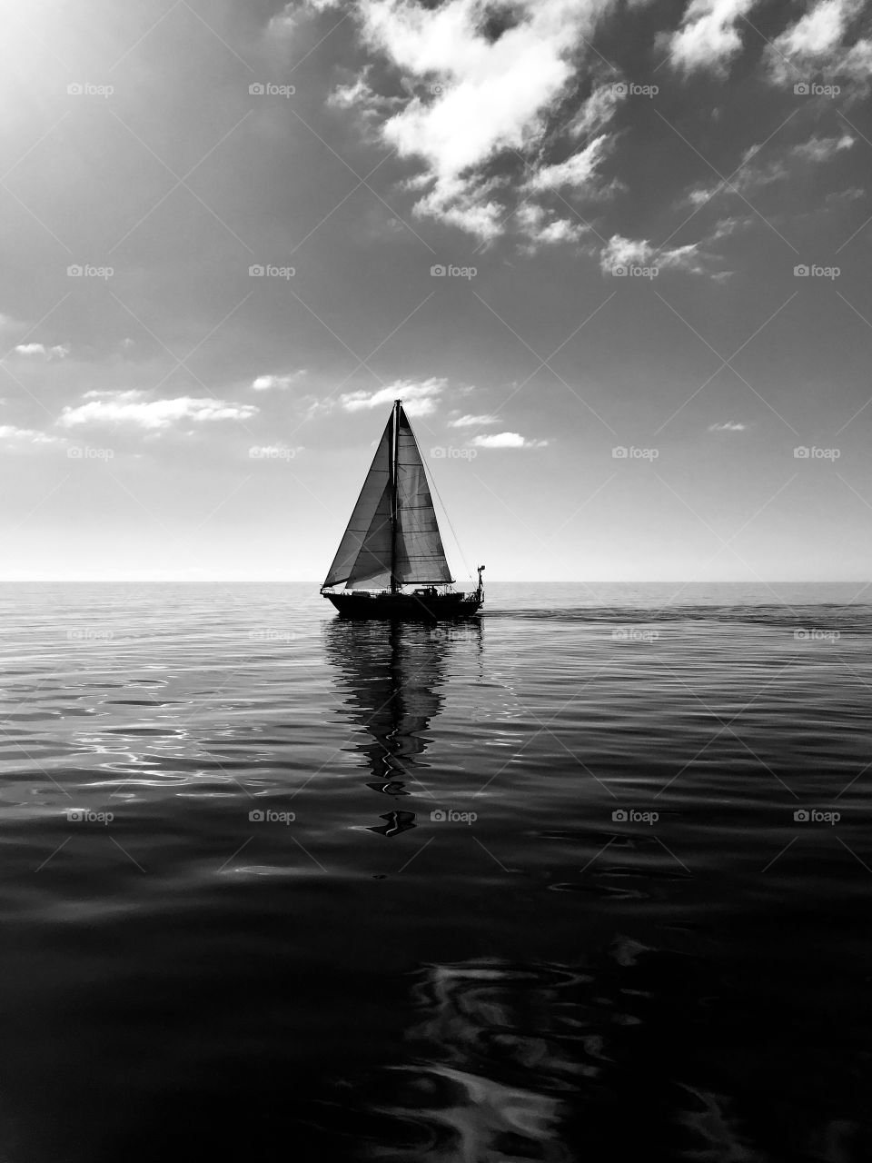 silhouette of a sail boat sailing in the ocean