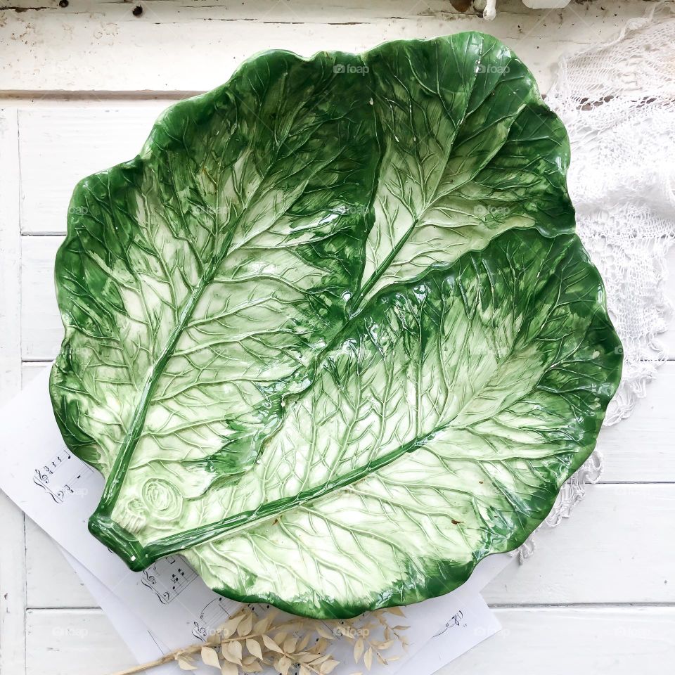 Old big dish in cabbage leaves form