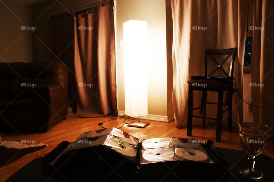 A movie organizer and binder lay out on a coffee table in a livingroom in preparation for a night in watching flicks.