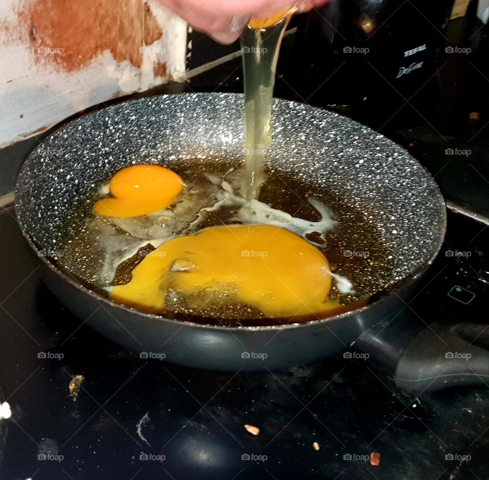 Tap an egg into the pan.