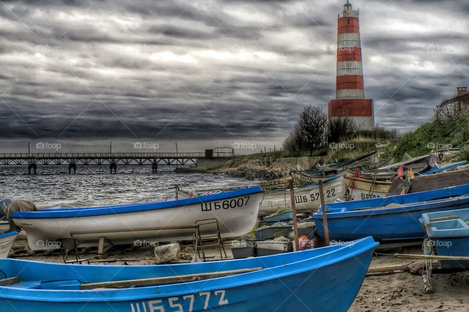 small harbor with boats and lighthouse