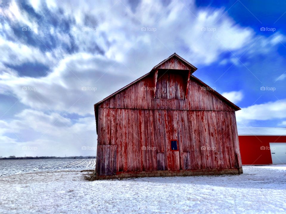 Old red barn in Indiana on a clear day after a snow 