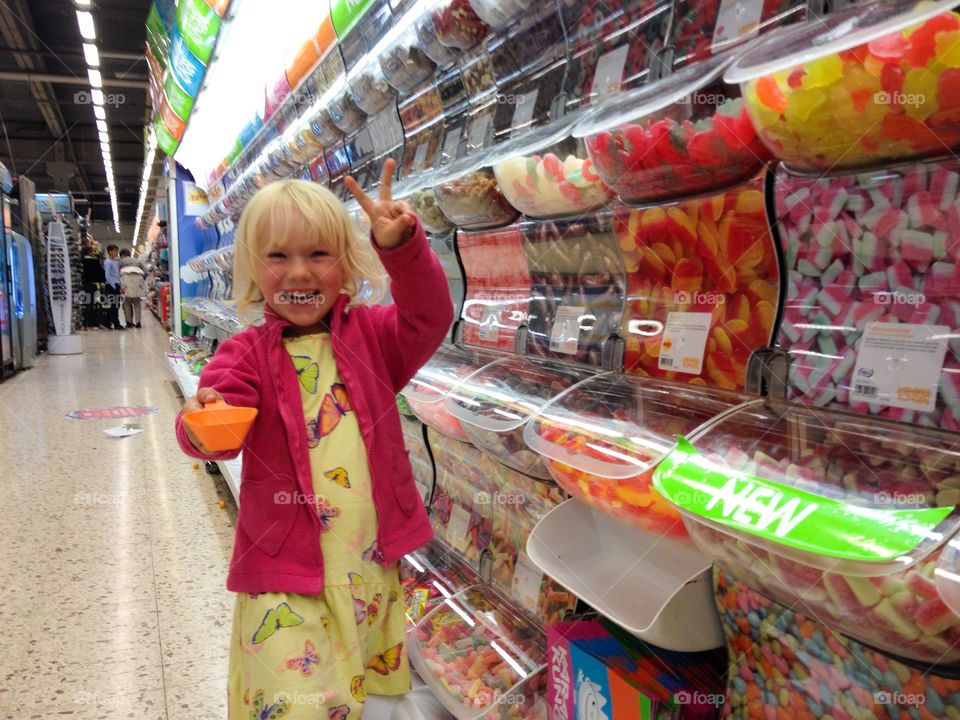 Little girl shopping Saturday candy in local store in Sweden.