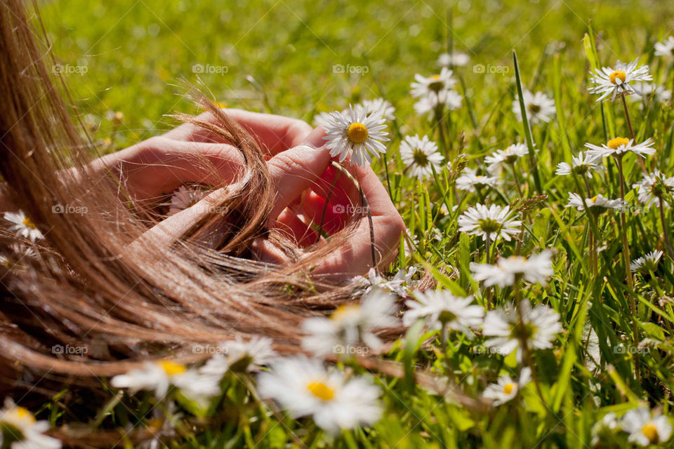 Girl playing with daisies on grass