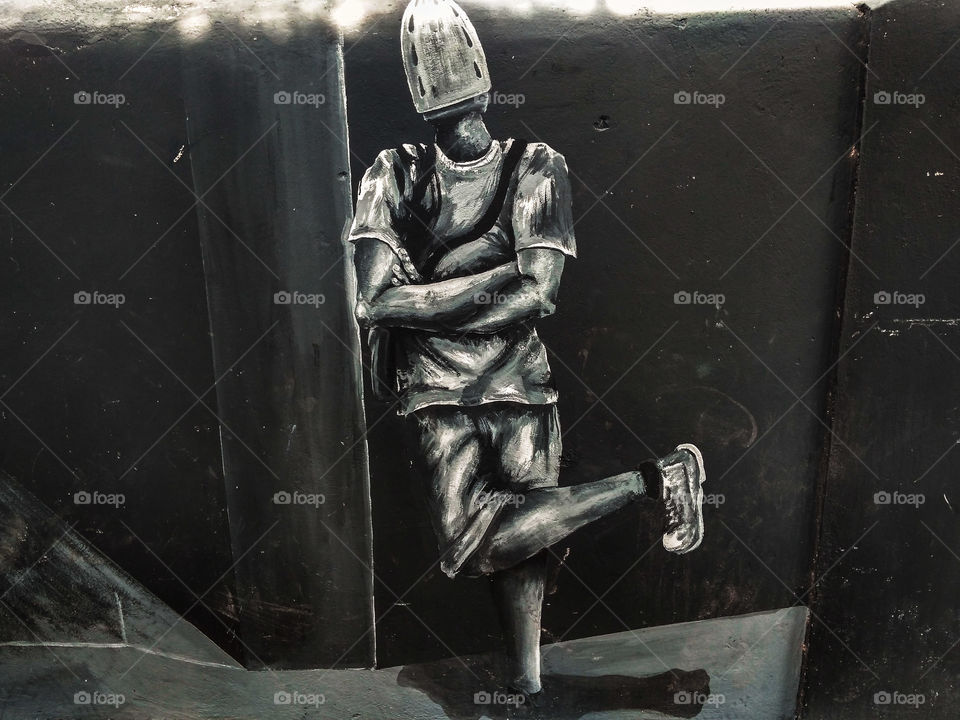 local art, painting of a man standing next to a wall..