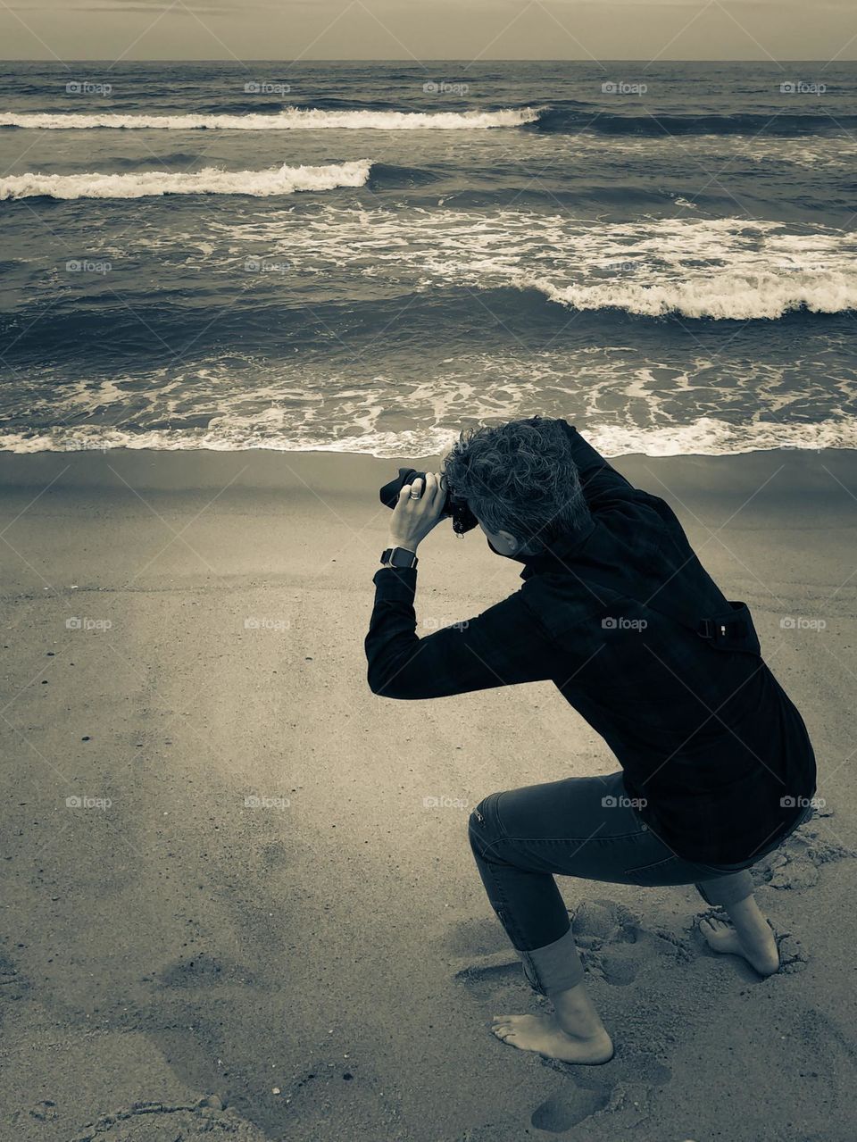 Photographer photographing the sea, photographer on the beach, photographer working on the beach, monochrome photo of the seaside, seaside vacations 