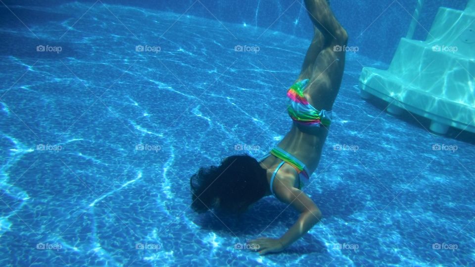 My little girl diving to the bottom of the swimming pool 