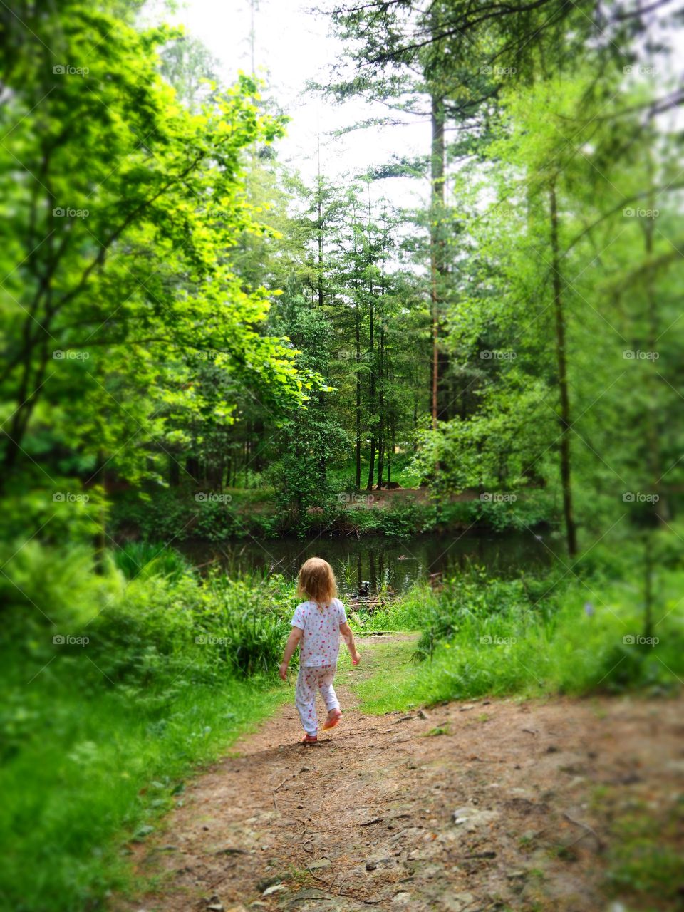 Child running through threes to pond