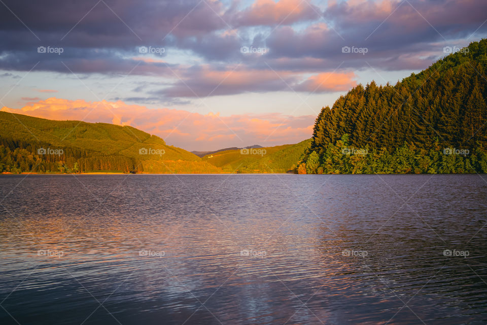 Scenic view of lake against sky during sunset .