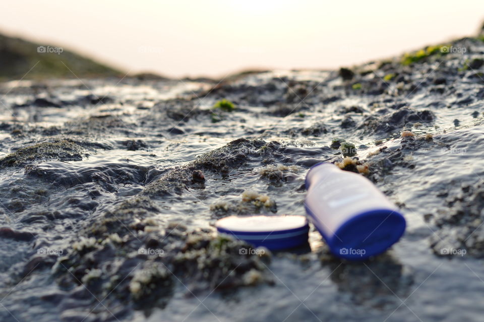 Nivea creme and Nivea body lotion are flaunted on the sea rock covered by beautiful Leathesia or Marine algae.