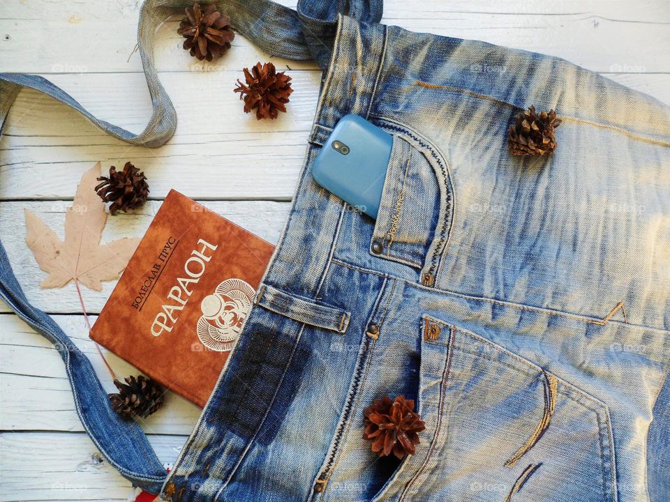 denim bag, book and smartphone are on the table