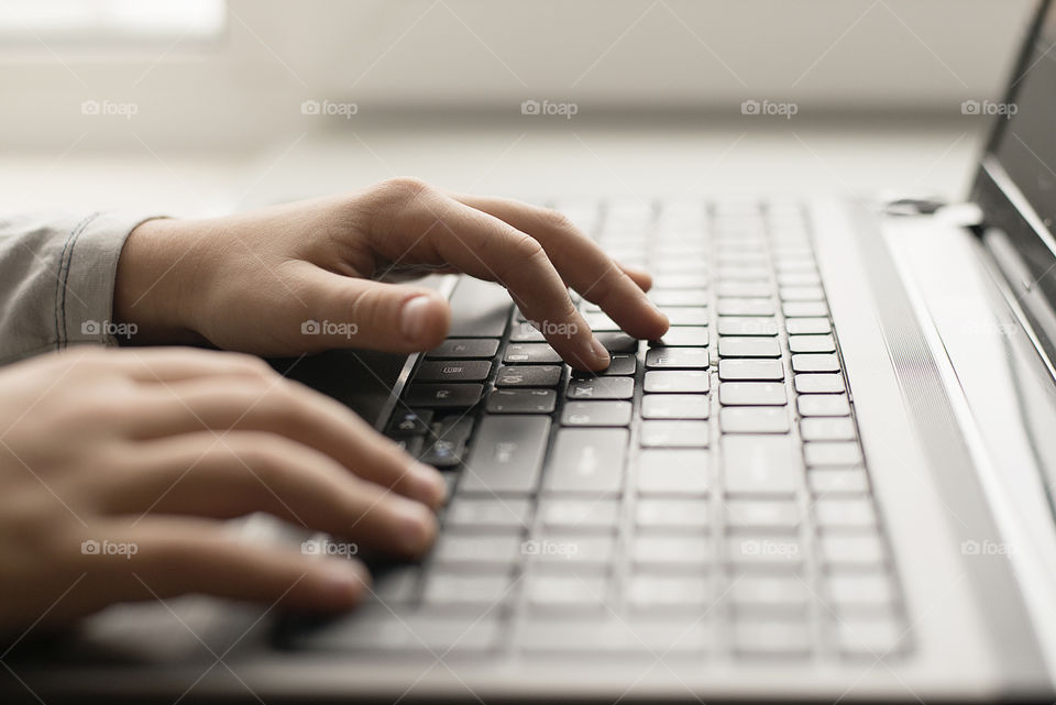 Child typing on a laptop