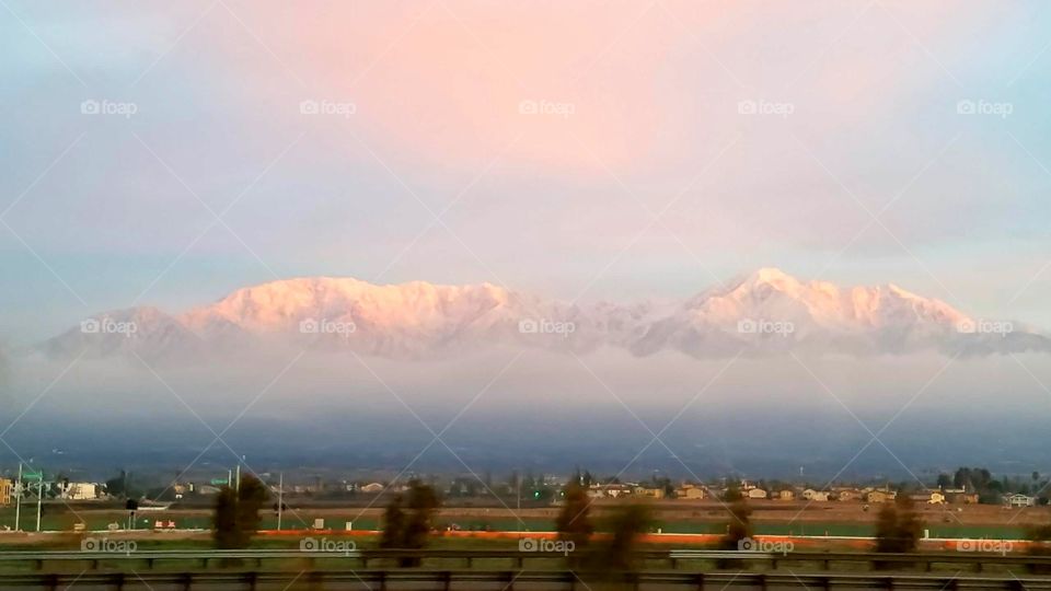 I know it looks really strange but there's a layer of fog at the bottom of the mountains and all you can see are the snow-capped Peaks and it looks like clouds but it isn't