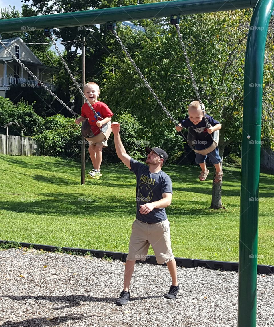 Dad swinging boys