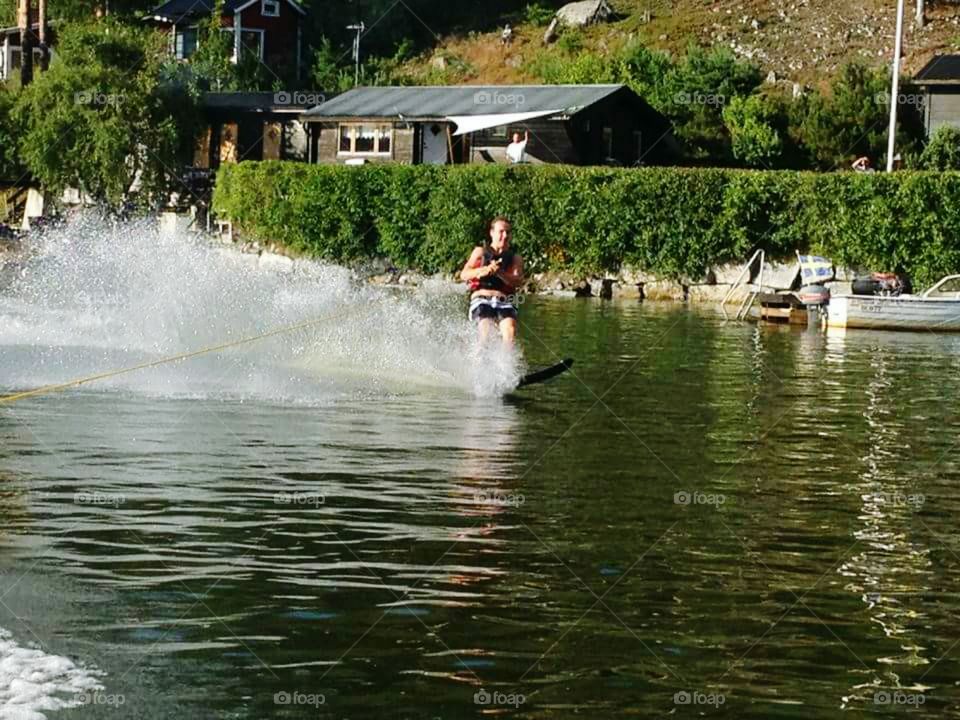 Young man wakeboarding on lake